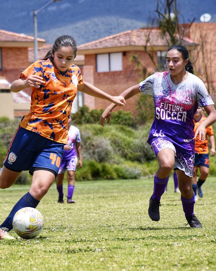 services-img Vibrant action capture of a women's soccer match, showcasing skill and teamwork outdoors.