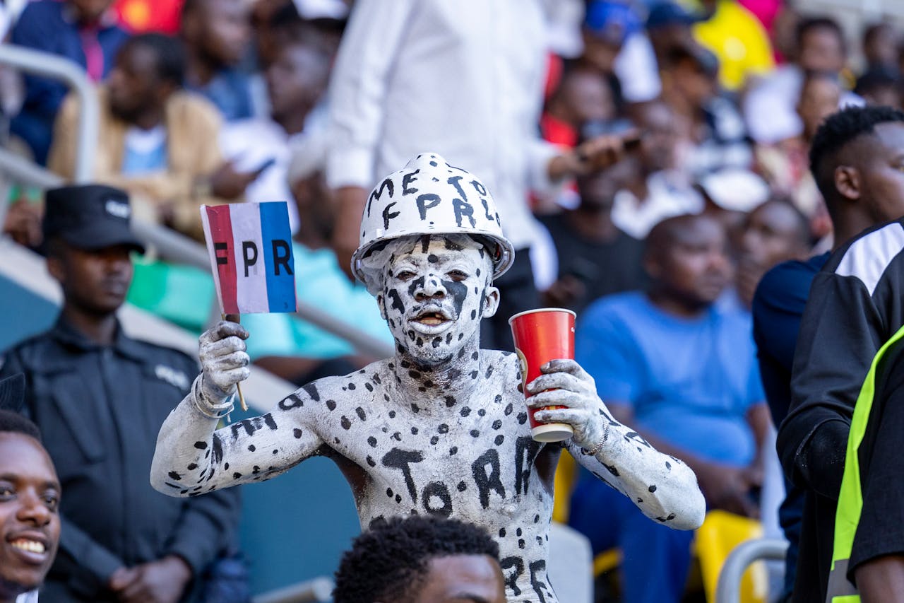 Enthusiastic sports fan with body paint holding a flag at a lively stadium.