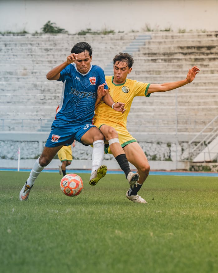 Action-packed soccer game with two players contesting for the ball on a bright day.
